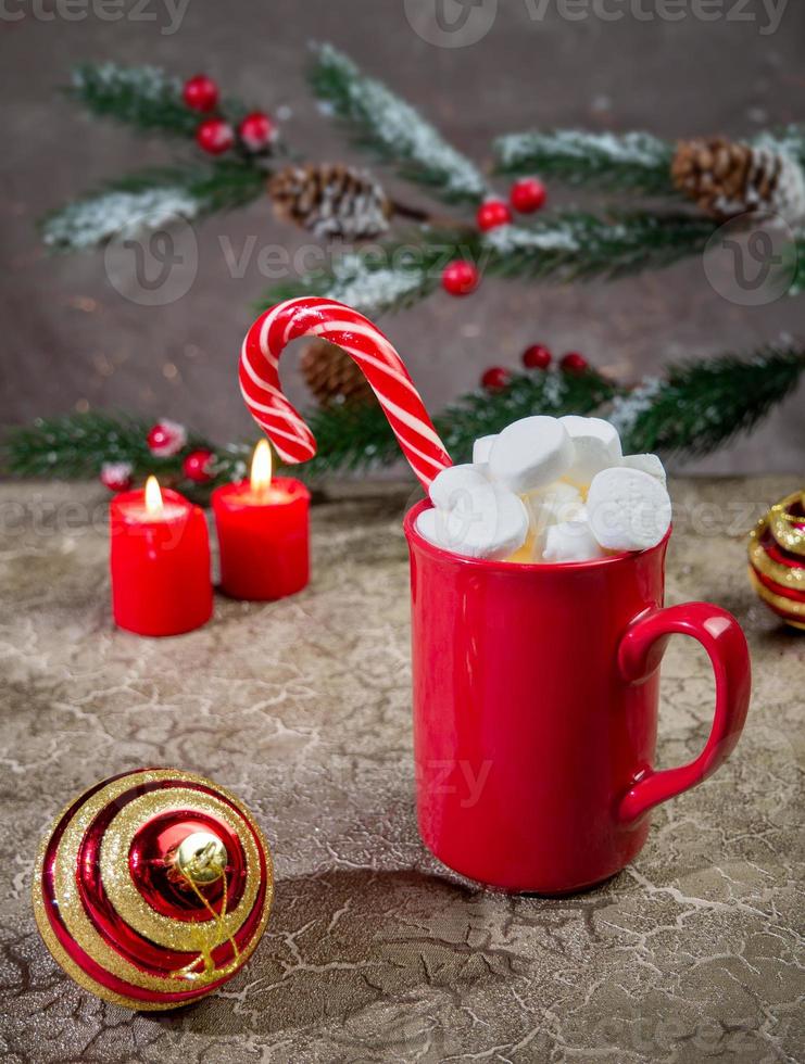 Hot winter drink chocolate with marshmallow and caramel cane in red mug with . Christmas time photo