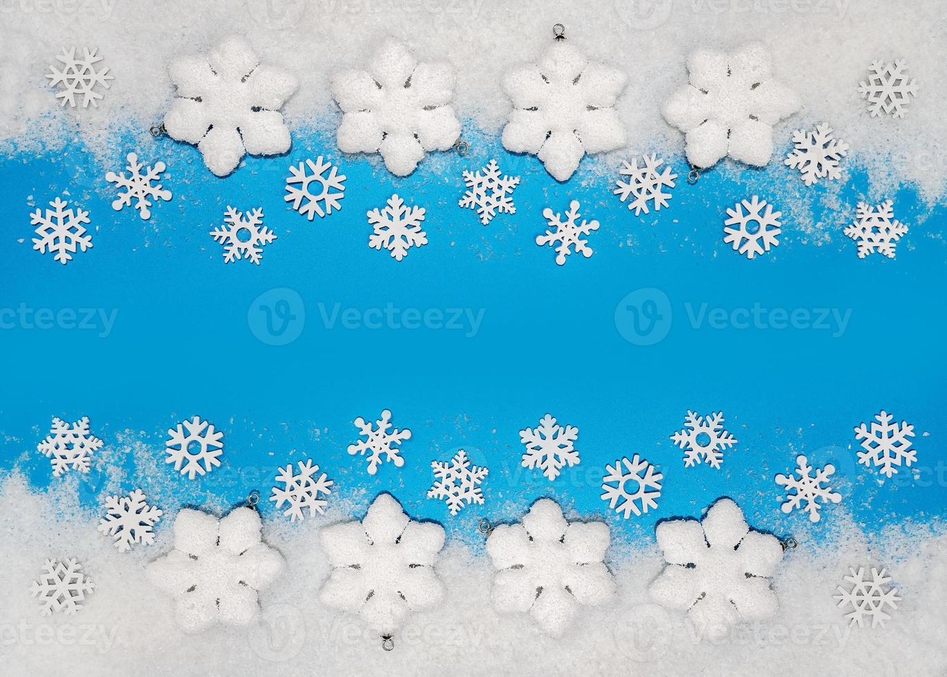 Christmas background. White decorations Christmas balls and snowflakes on soft snow, copy space, place for text photo