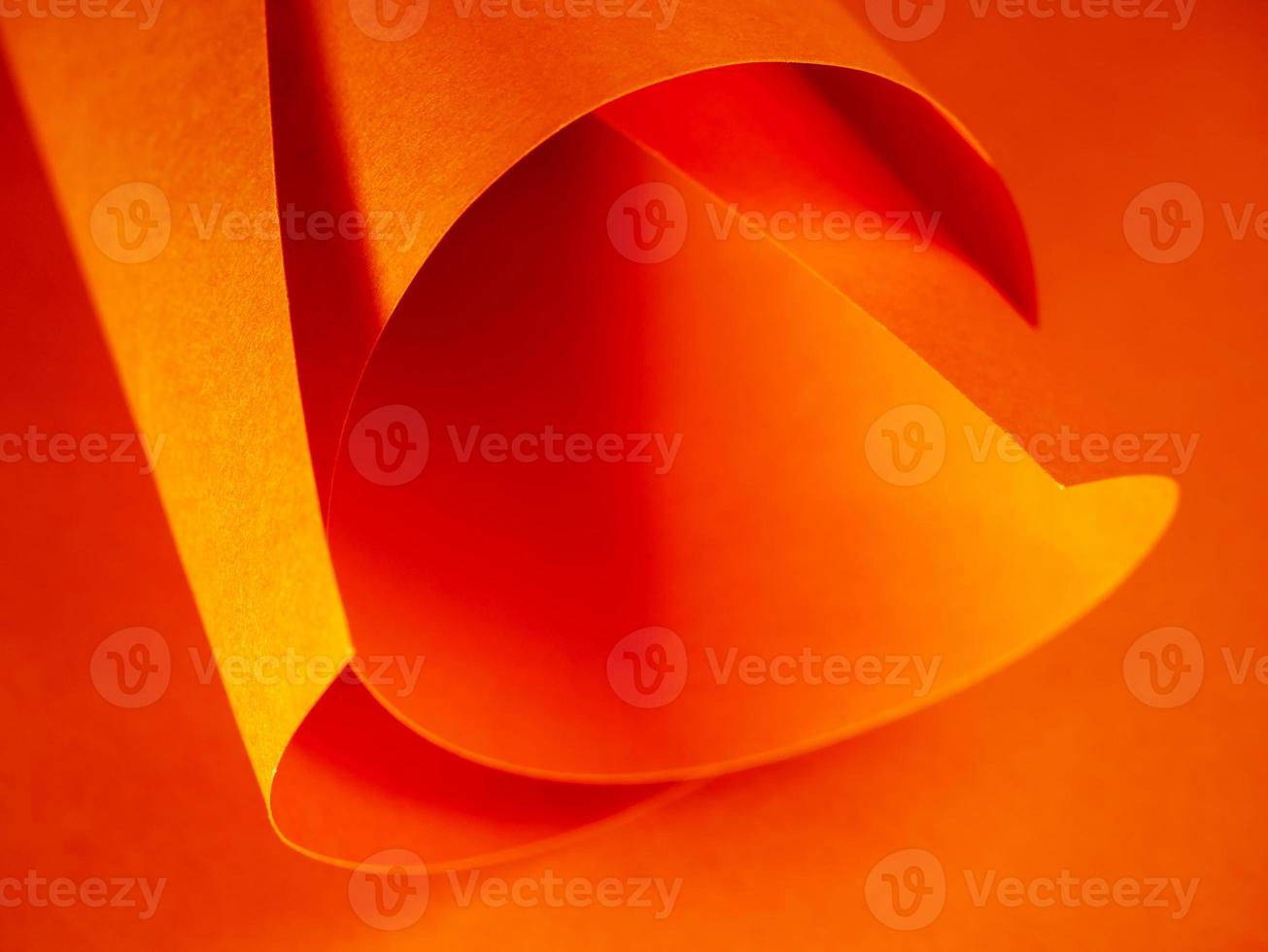 Colored paper rolled up. Abstract bright orange paper background for your design. Selected sharpness. photo
