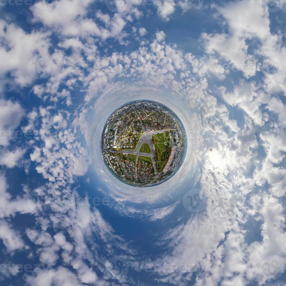 tiny planet in sky with clouds overlooking old town, urban development, historic buildings and crossroads. Transformation of spherical 360 panorama in abstract aerial view. photo