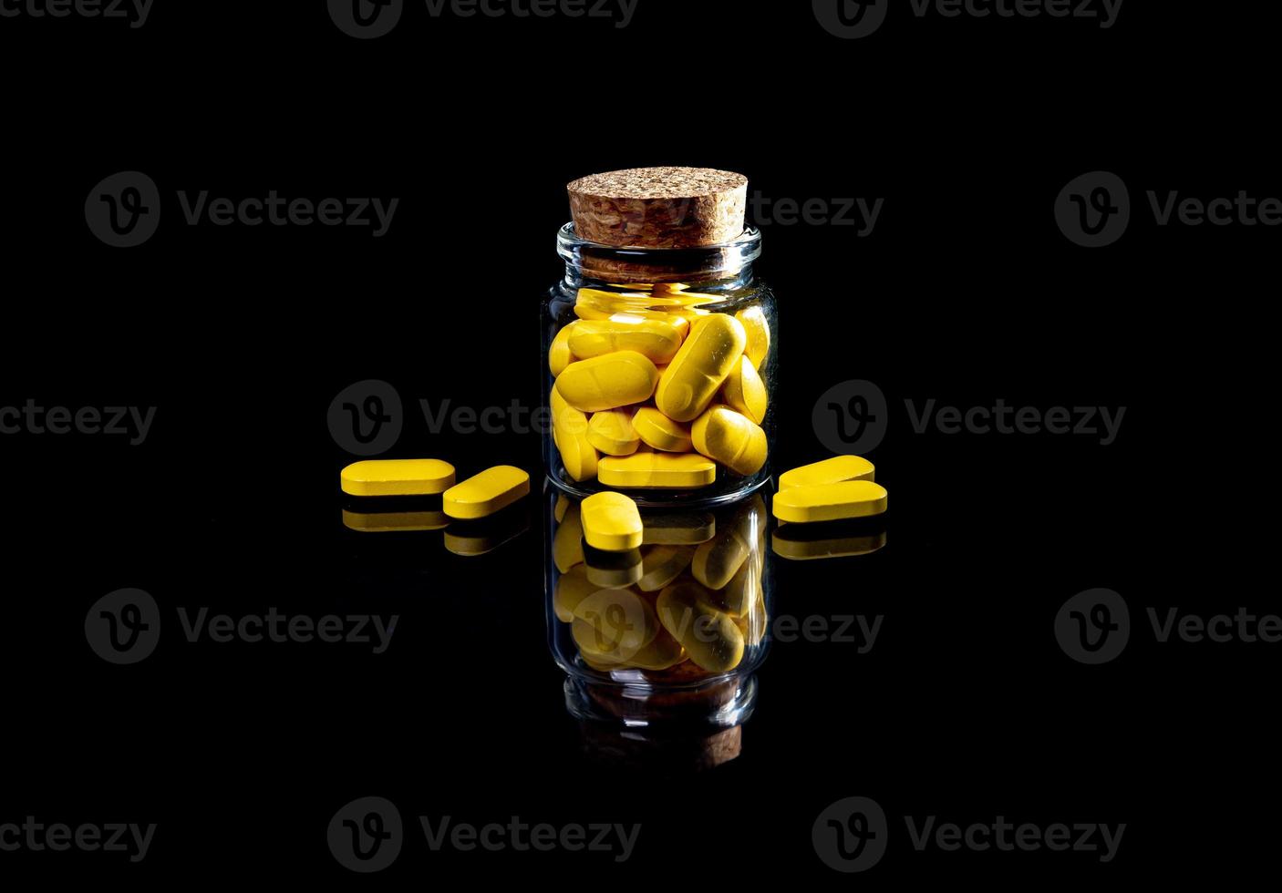 white orange pills in wineglass glass . in jar. in bucket Isolated on black set of capsule and pills inside closeup, photo