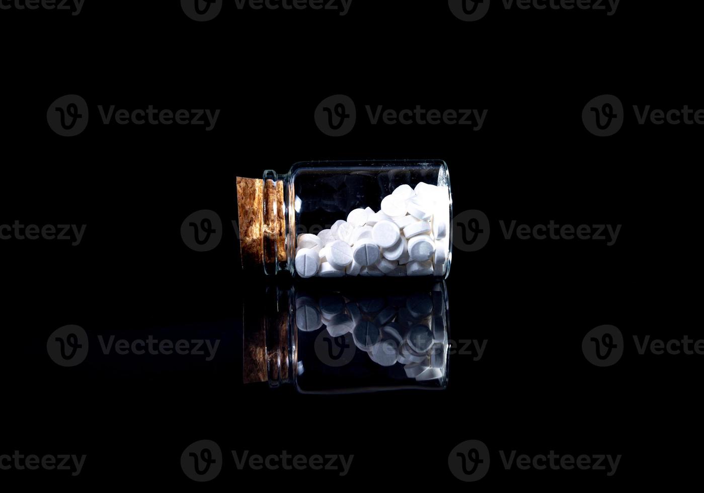 white orange pills in wineglass glass . in jar. in bucket Isolated on black set of capsule and pills inside closeup, photo