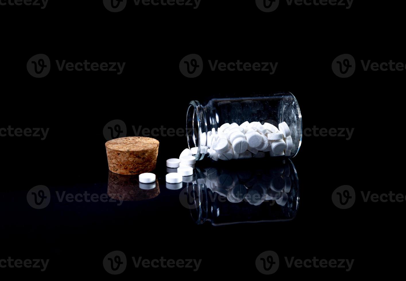 white orange pills in wineglass glass . in jar. in bucket Isolated on black set of capsule and pills inside closeup, photo