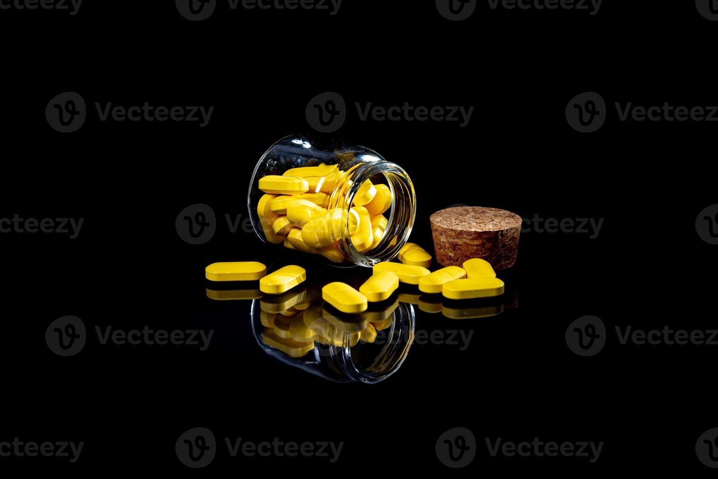 white orange pills in wineglass glass . in jar. in bucket Isolated on black set of capsule and pills inside closeup, photo