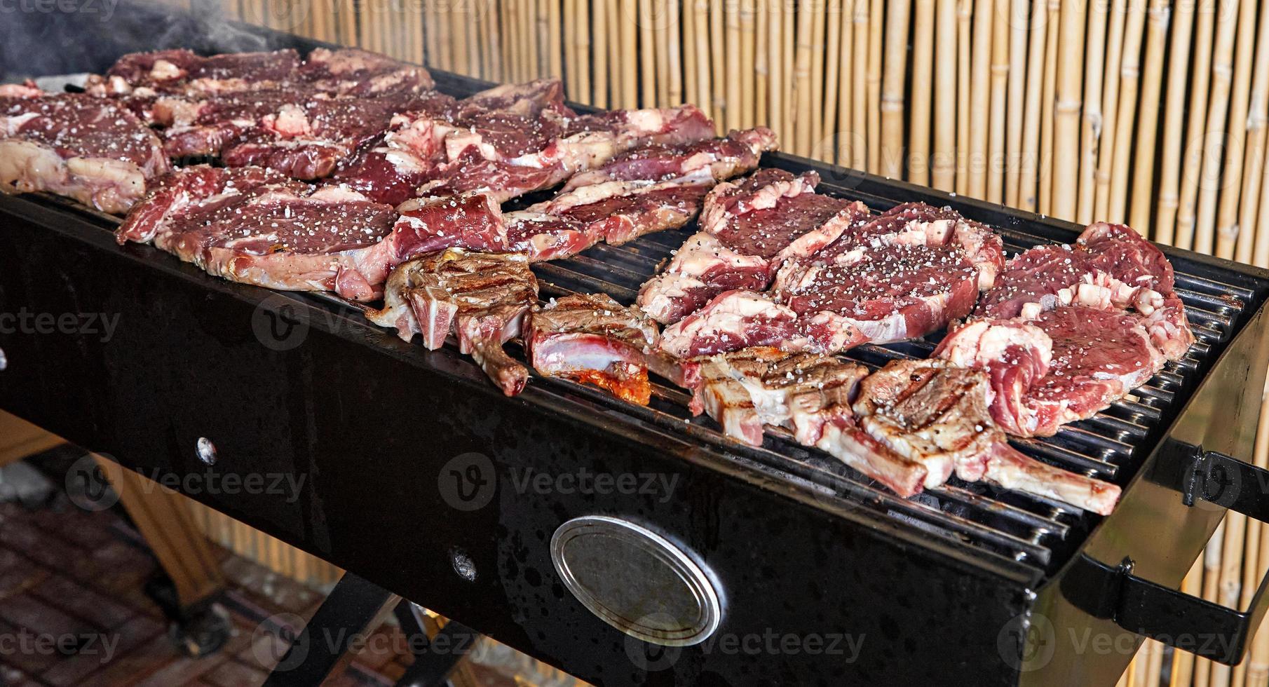Lamb ribs and steaks are cooked on the grill for serving in catering photo