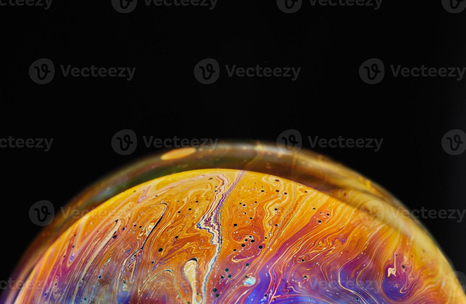 Virtual reality space with abstract multicolor psychedelic planet. Closeup Soap bubble like an alien planet on black background photo