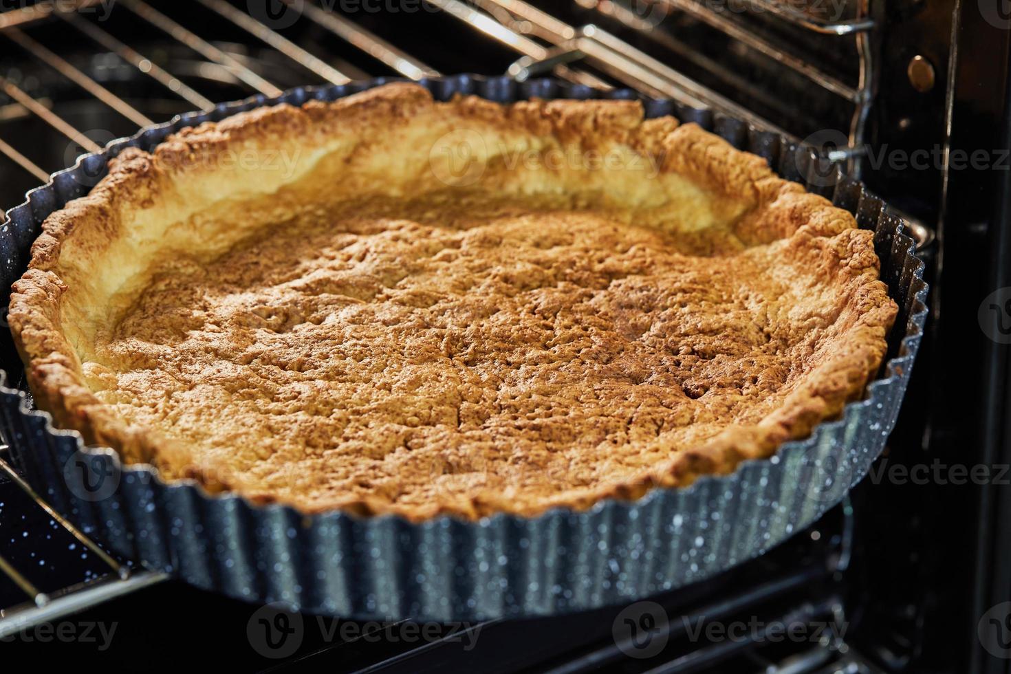 Pie base in metal baking dish after baking in an electric oven photo