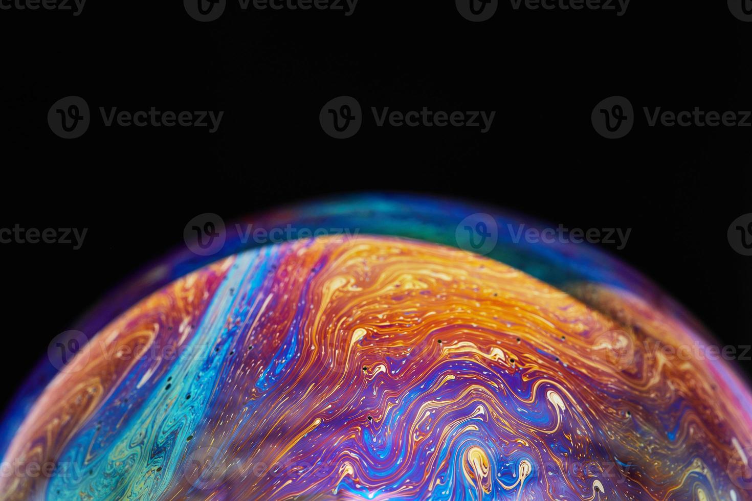 Virtual reality space with abstract multicolor psychedelic planet. Closeup Soap bubble like an alien planet on black background photo