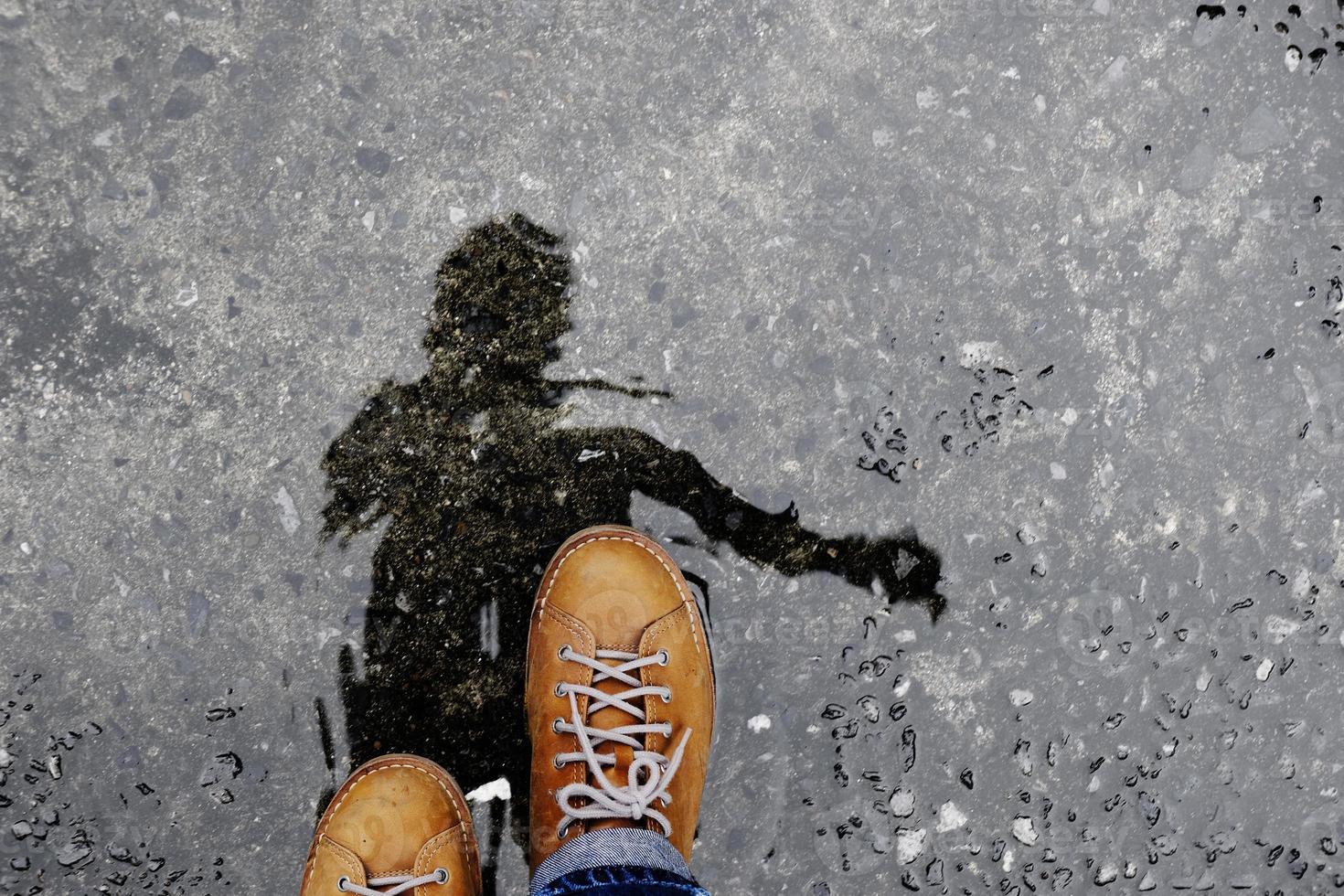 Top View of Male Walking on the Wet Ground after stopped Raining. Shadow Reflect on the Floor photo