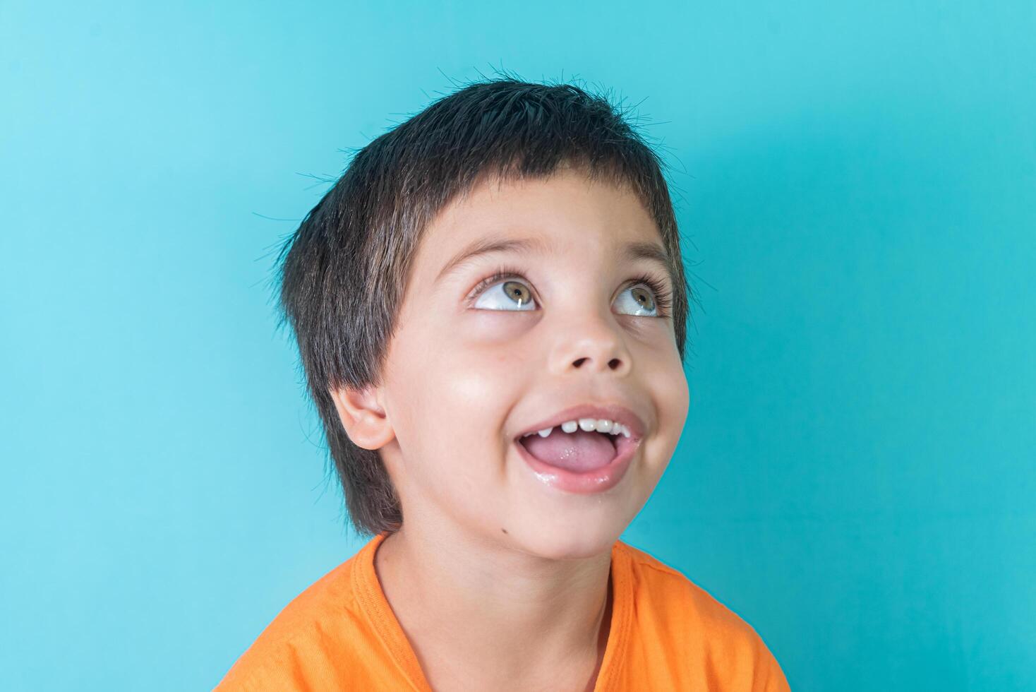 Boy in orange tshirt with funny face 13944489 Stock Photo at Vecteezy
