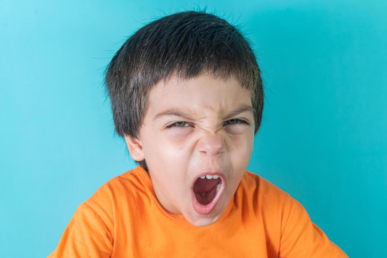 Boy in orange tshirt with funny face 13944516 Stock Photo at Vecteezy