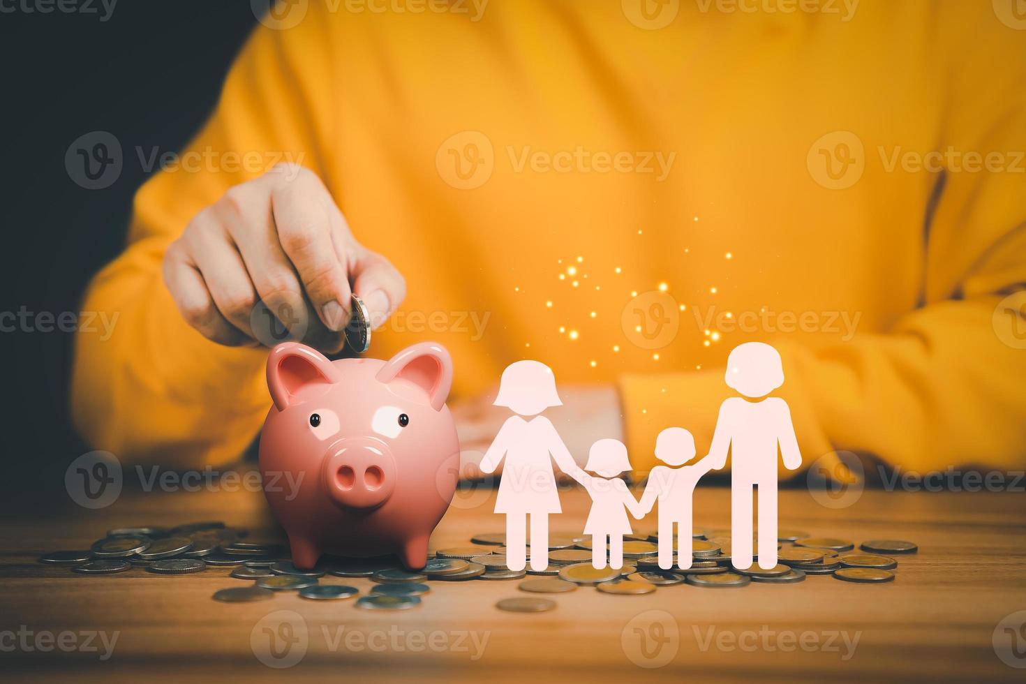 Father putting coins on piggy bank with family icon on the table. Concept savings money for education, travel, family financial plan, retire, investment, financial crisis, health. photo