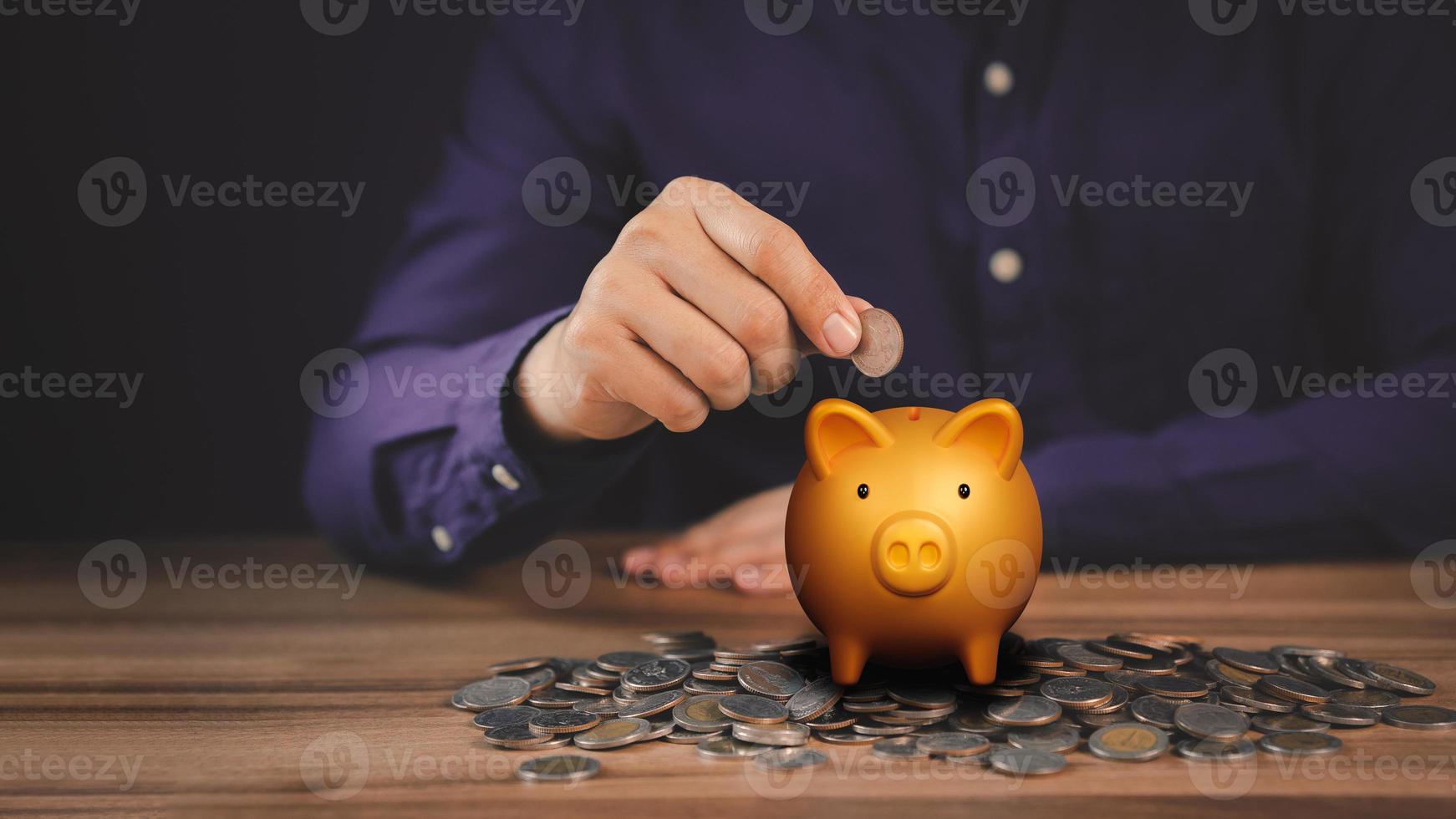 Man putting coin into piggy bank for saving money concept, business finance and investment. photo