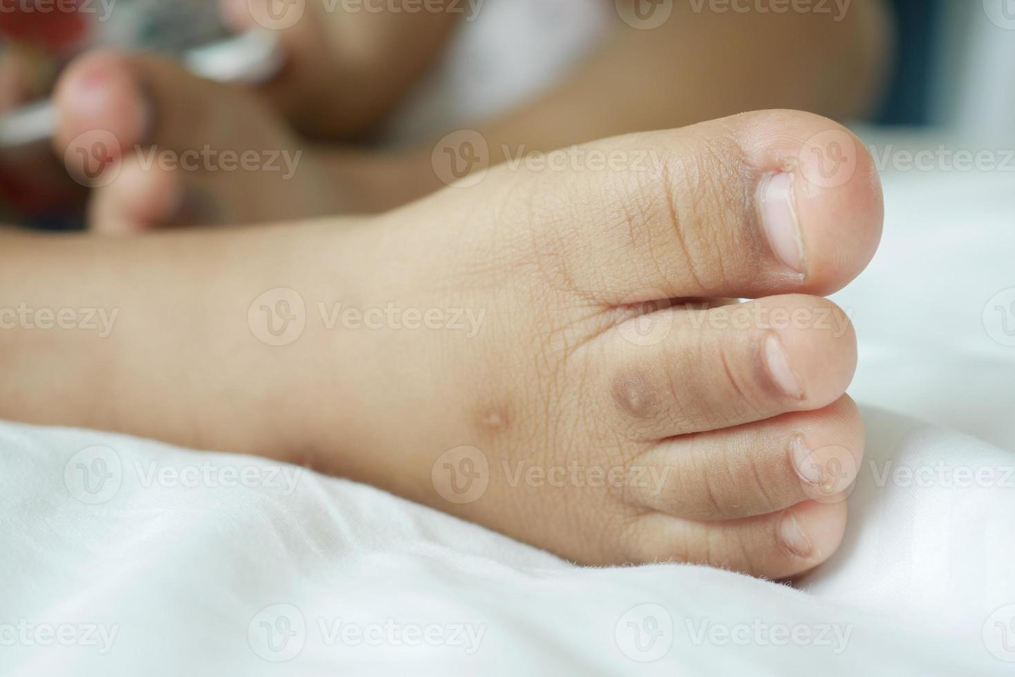 cerca de un niño de 5 años con los pies secos en la cama foto