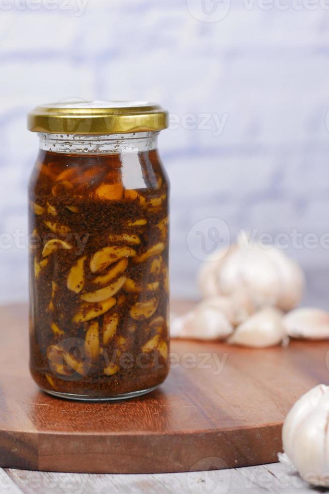 Homemade Garlic Pickle in a glass jar on table , photo