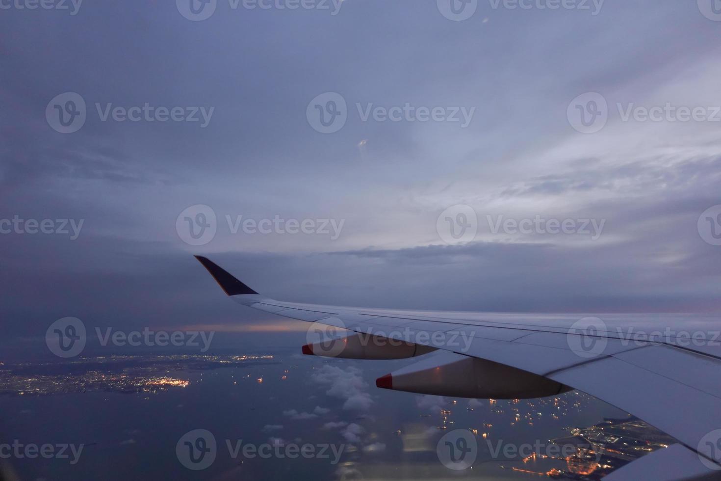 Wing of aircraft flying above the clouds photo