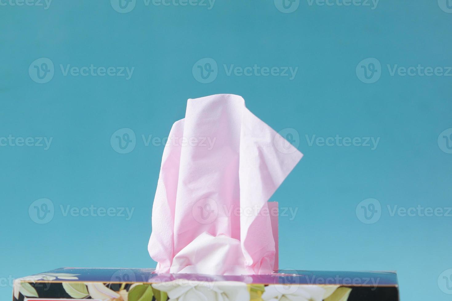hand pull out a piece of tissue from tissue paper box photo