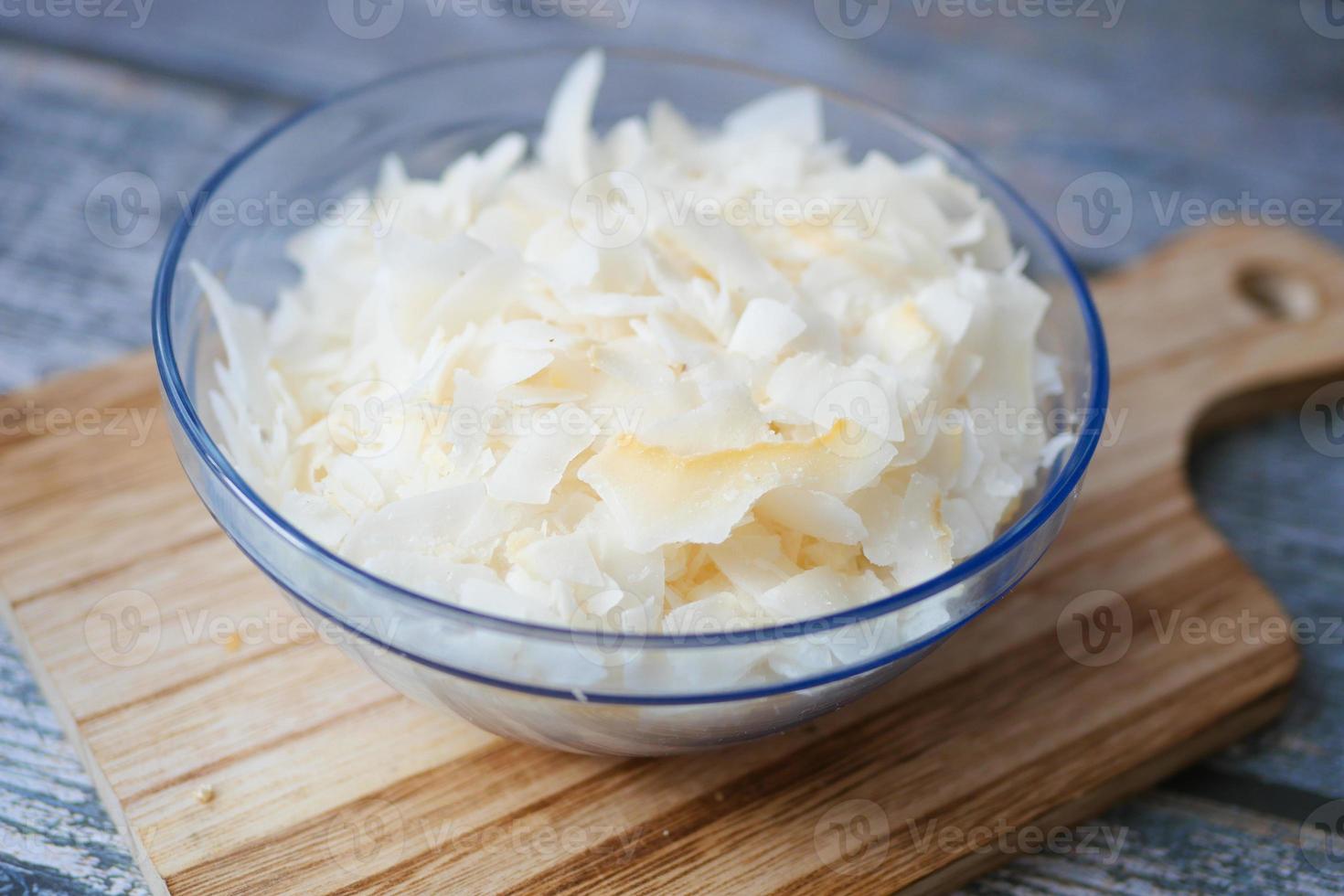 slice of fresh coconut flakes in a bowl on a table photo