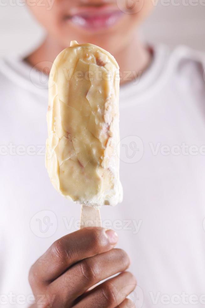 young men eating vanila flavor ice cream in a container photo