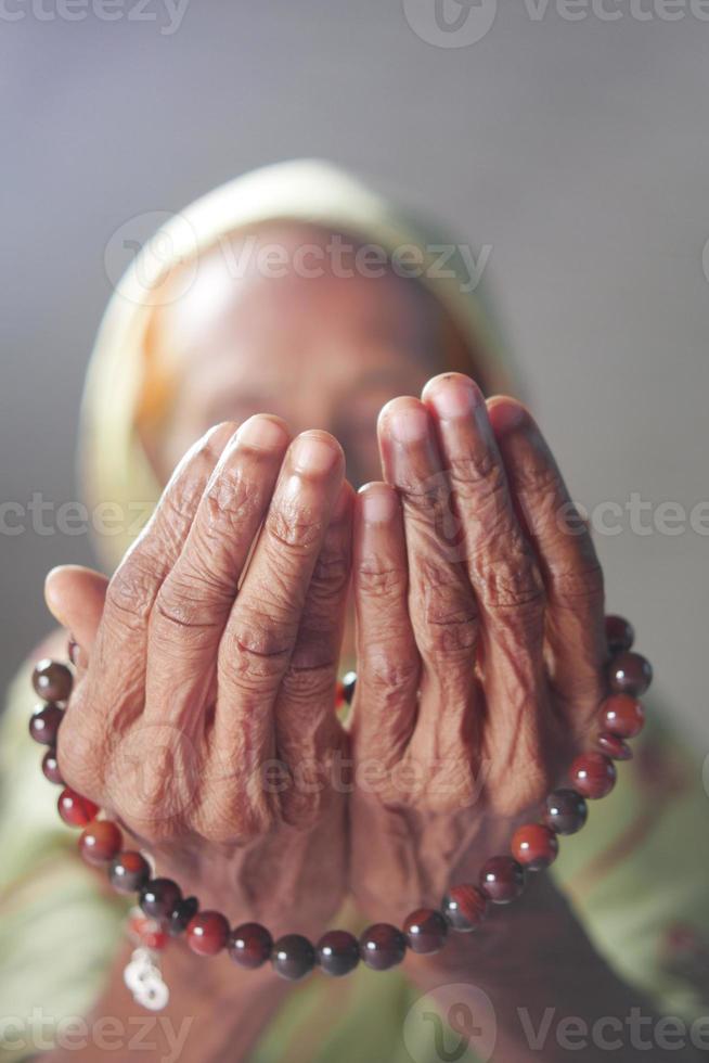 Cerca de la mano de las mujeres mayores orando en Ramadán foto