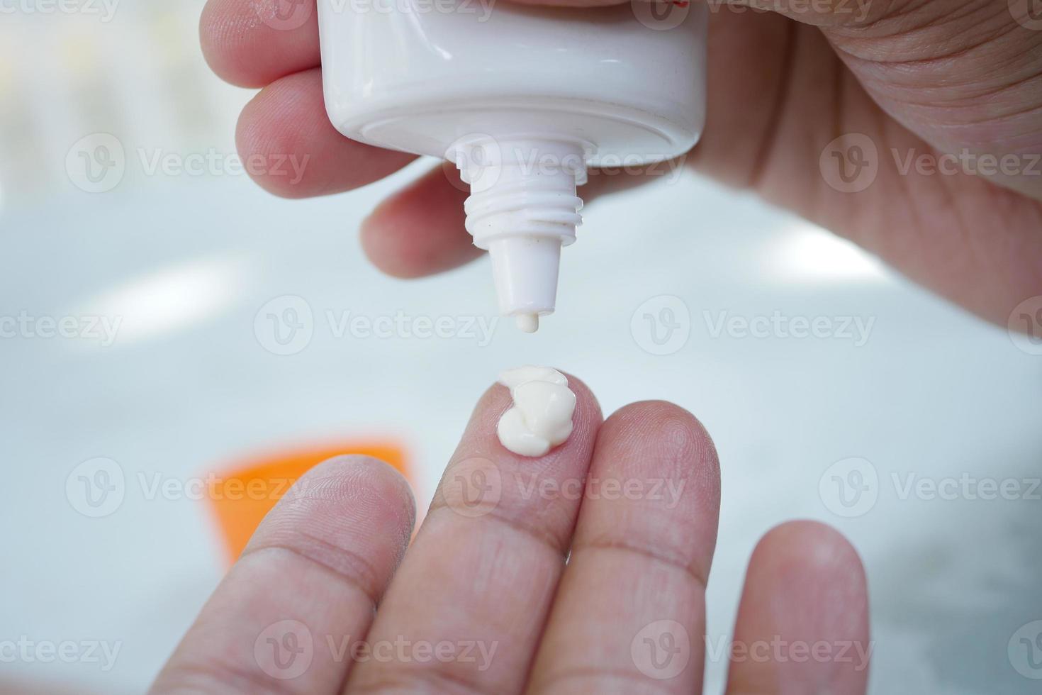 Close up of person hand using sunscreen cream photo