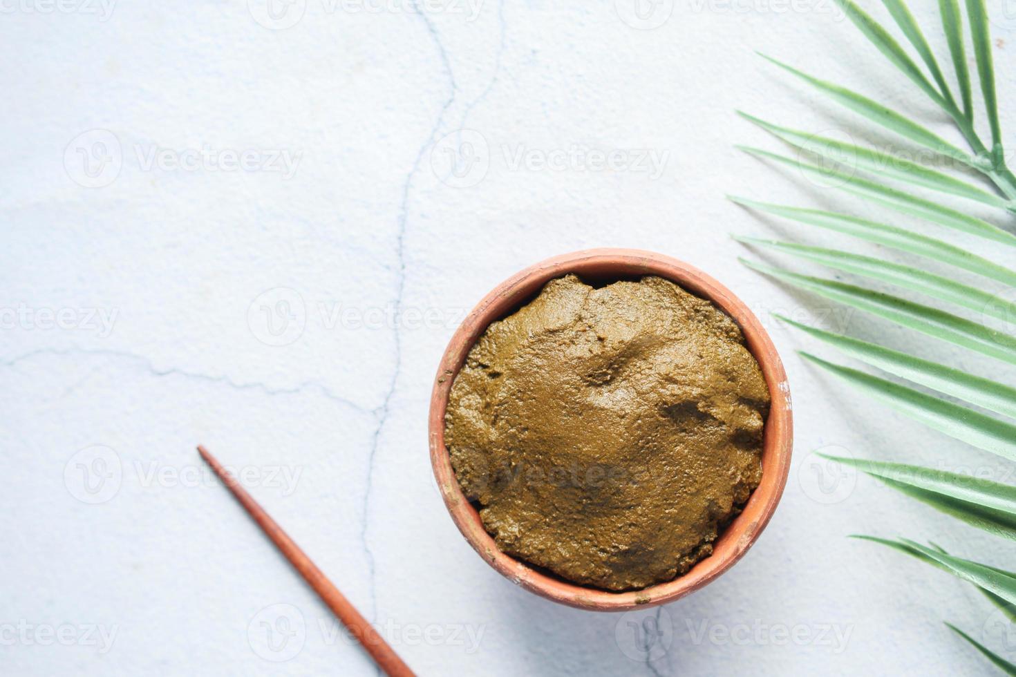 The wooden bowl with rehydrated henna on table photo