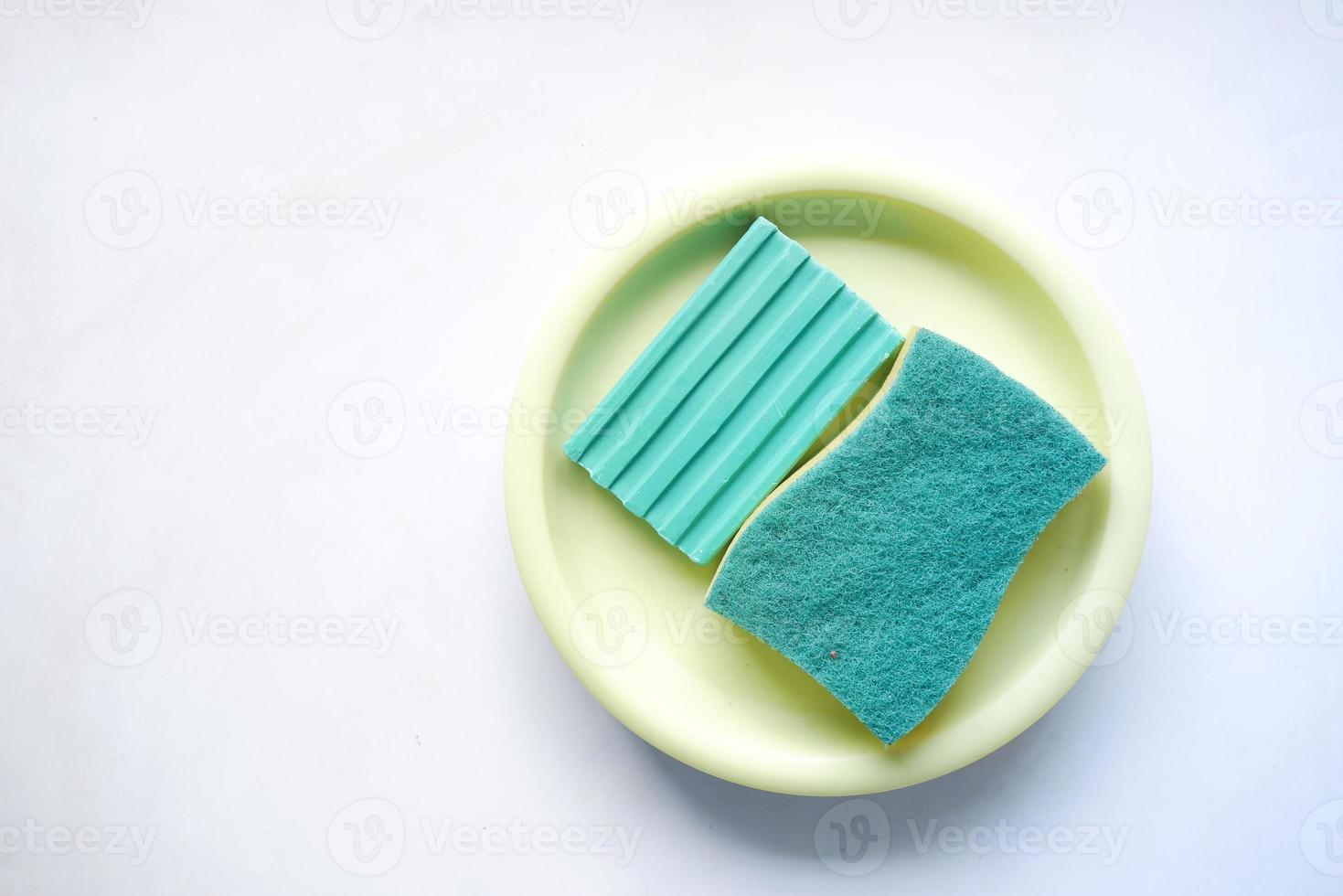 sponge , rubber gloves and colorful plate on pink photo