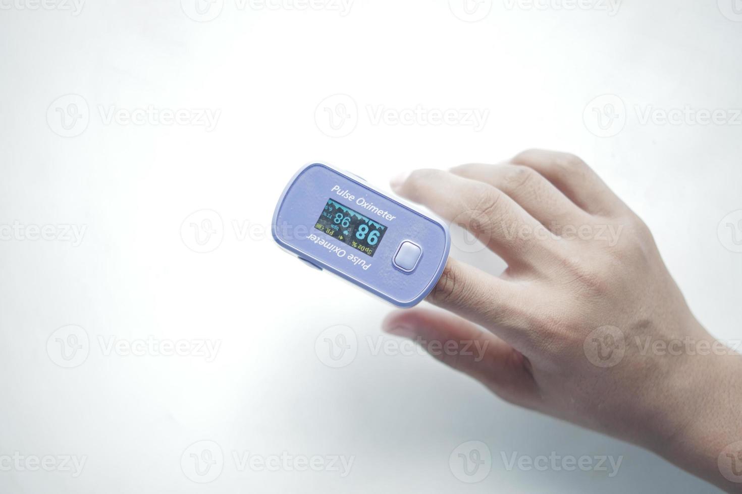 close up of man hand using pulse oximeter photo