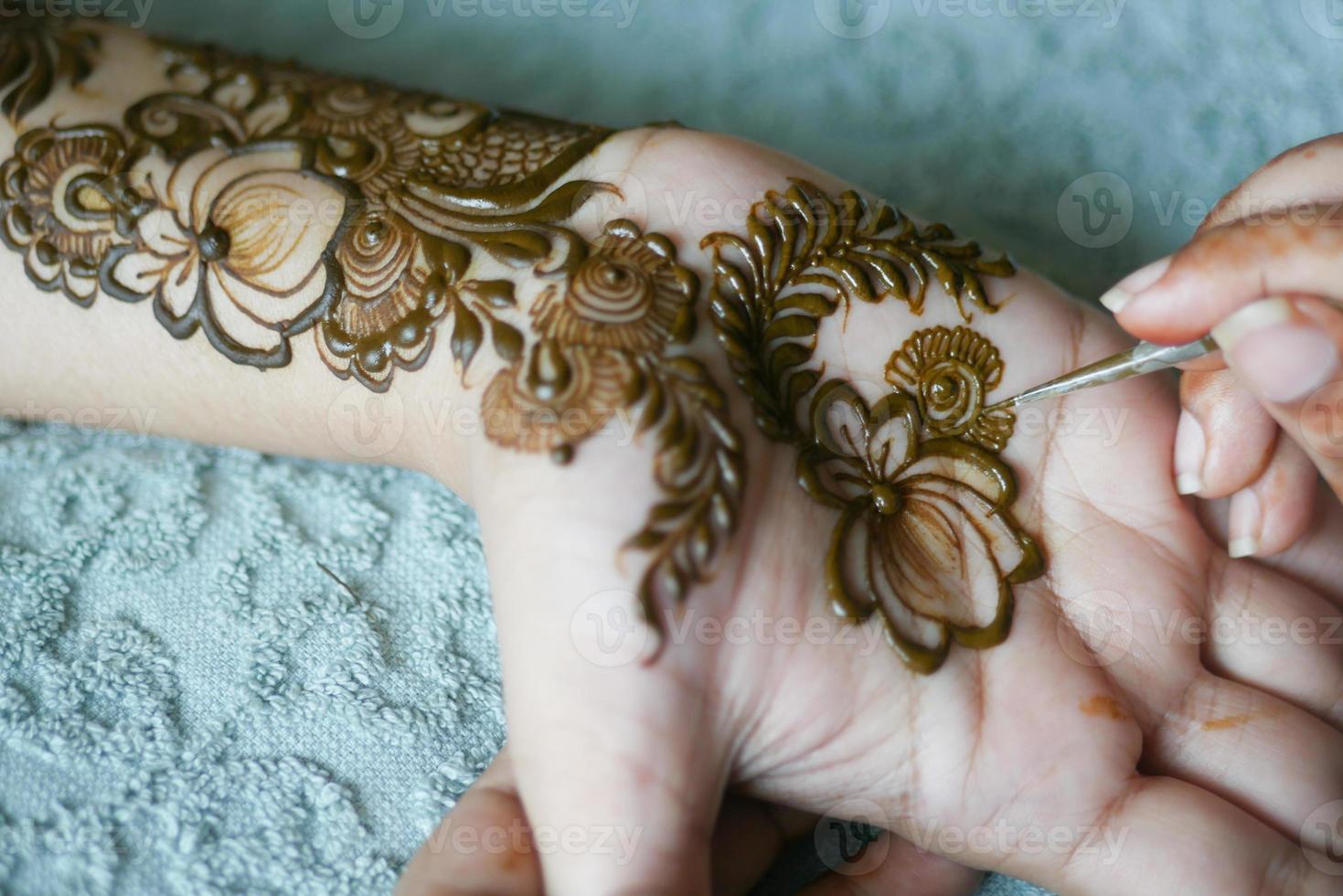 women applying henna on hand photo