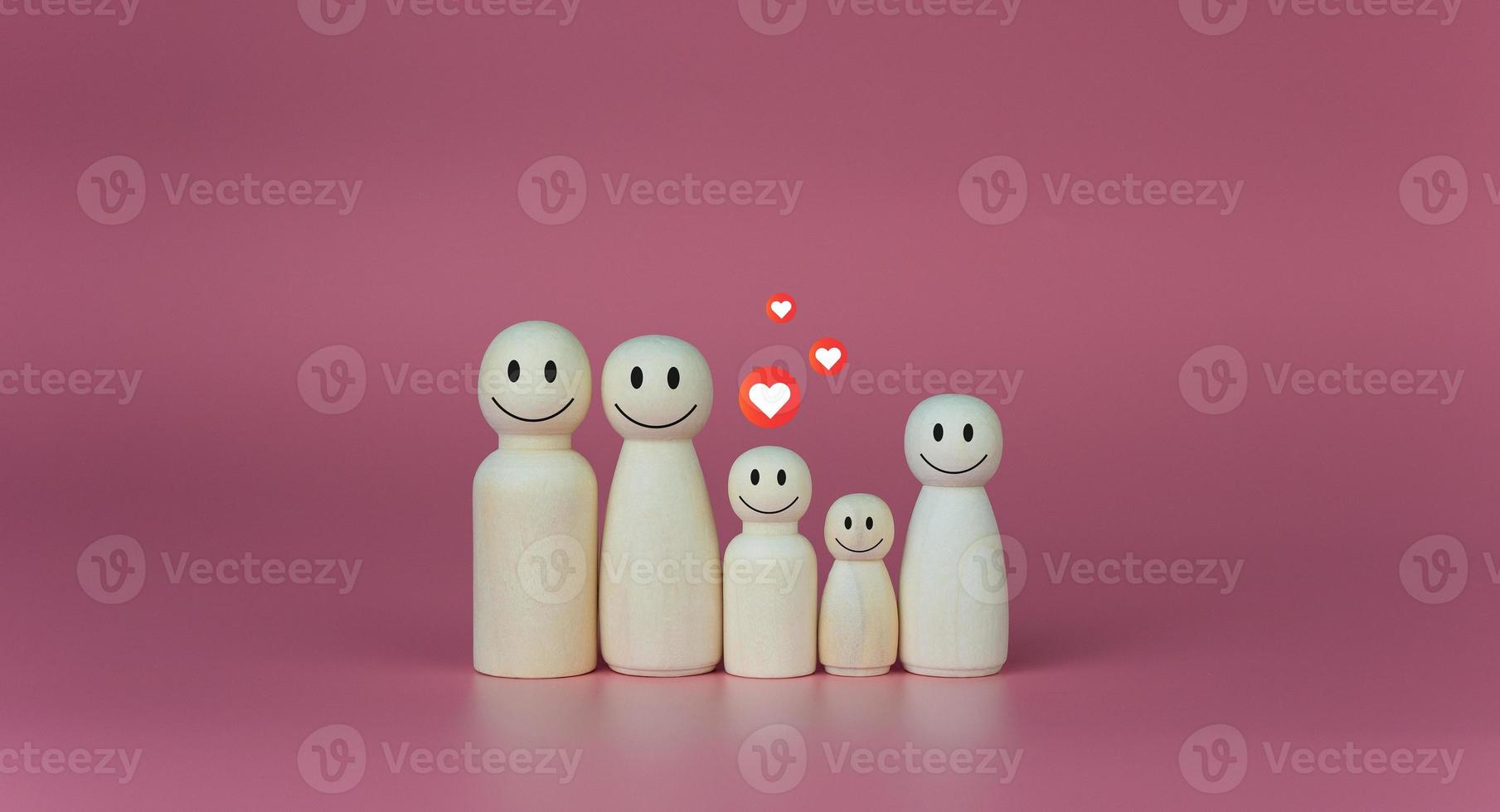 Happy house concept. Wooden dolls stand lined up with heart icons. Indicates happiness and love in the home. photo