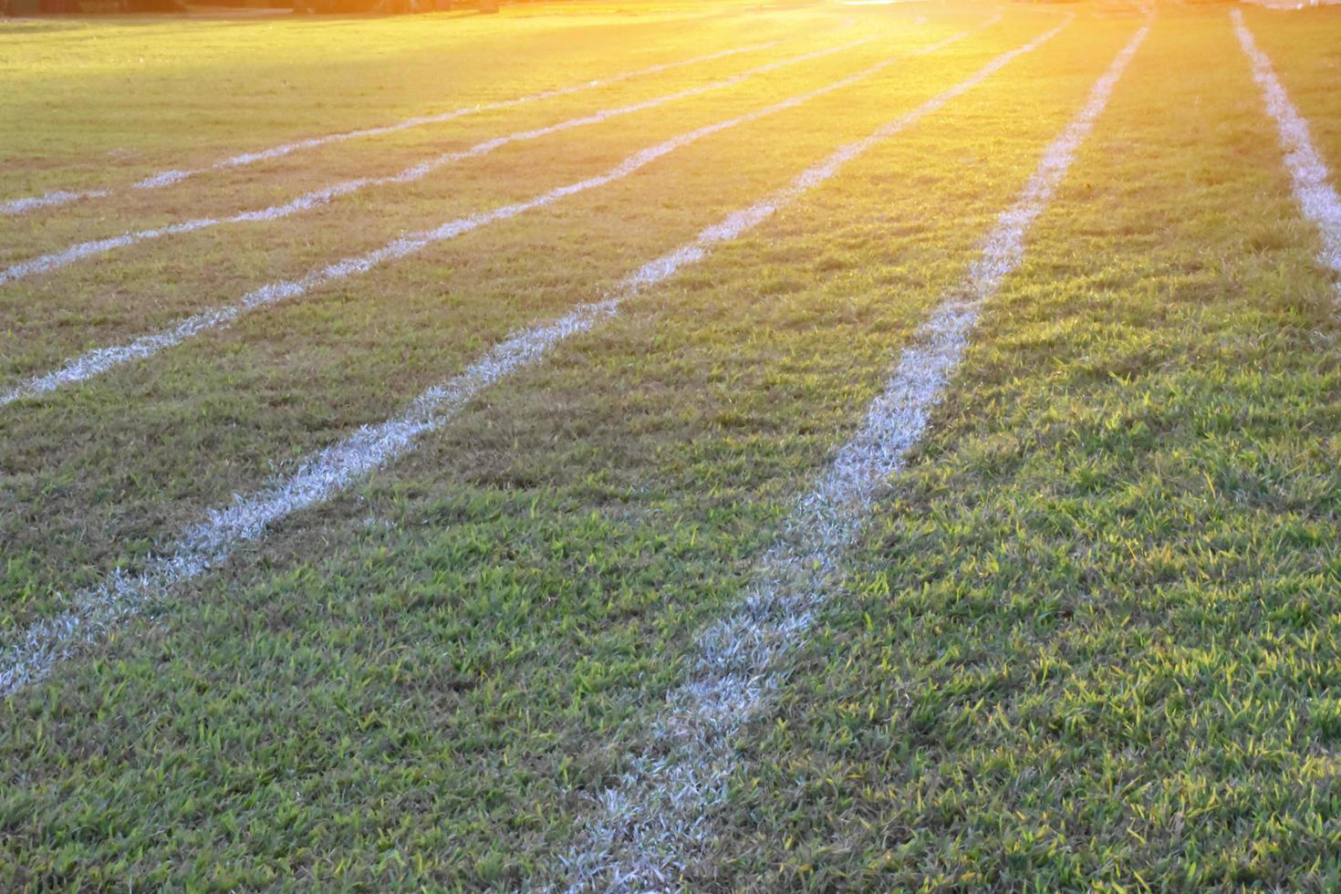 Outdoor white lines on grass field for practisting running at school in long distance area of Thaland. photo