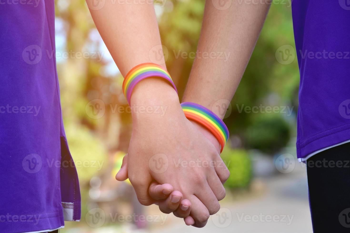 Rainbow wristband wearing in hand of young asian gay to show and represent gender diversity, to respect human rights in alternative sex, to stop punishing homosexuals in some religions photo