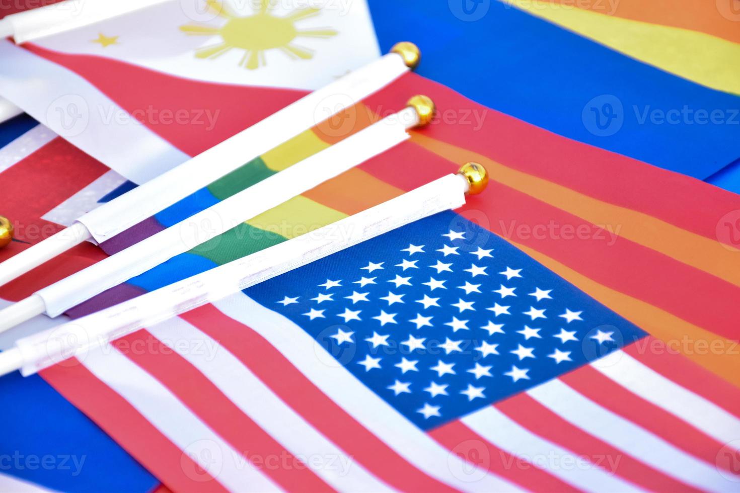 banderas del arco iris y banderas de muchos países en el piso, concepto para la celebración de lgbtq más géneros en el mes del orgullo en todo el mundo, enfoque suave y selectivo. foto