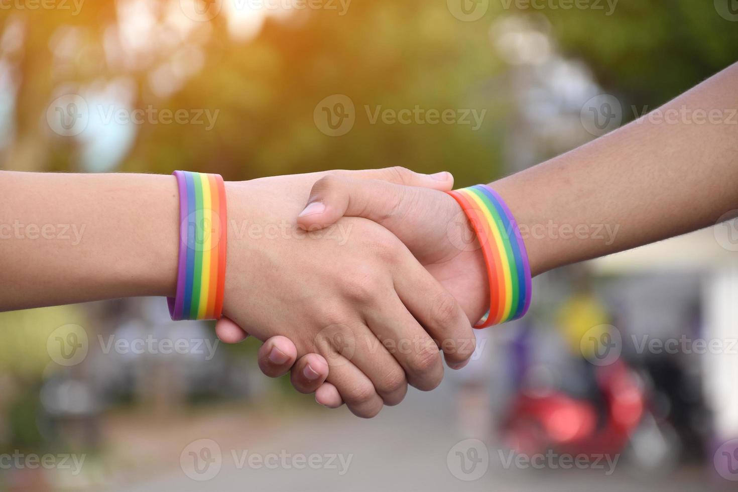 Rainbow wristband wearing in hand of young asian gay to show and represent gender diversity, to respect human rights in alternative sex, to stop punishing homosexuals in some religions photo