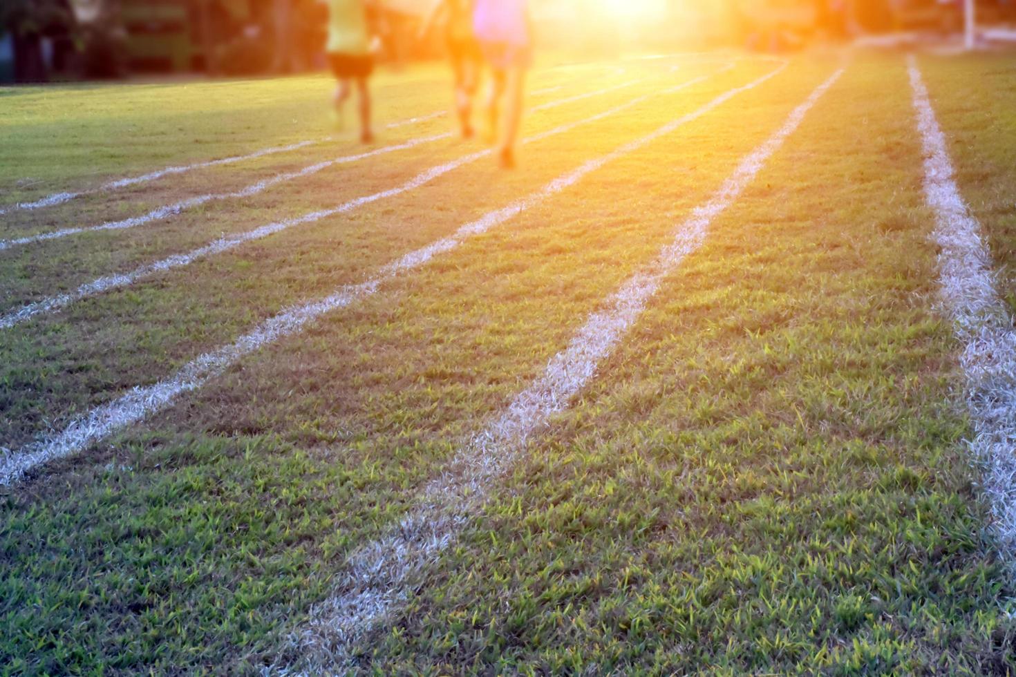 Outdoor white lines on grass field for practisting running at school in long distance area of Thaland. photo