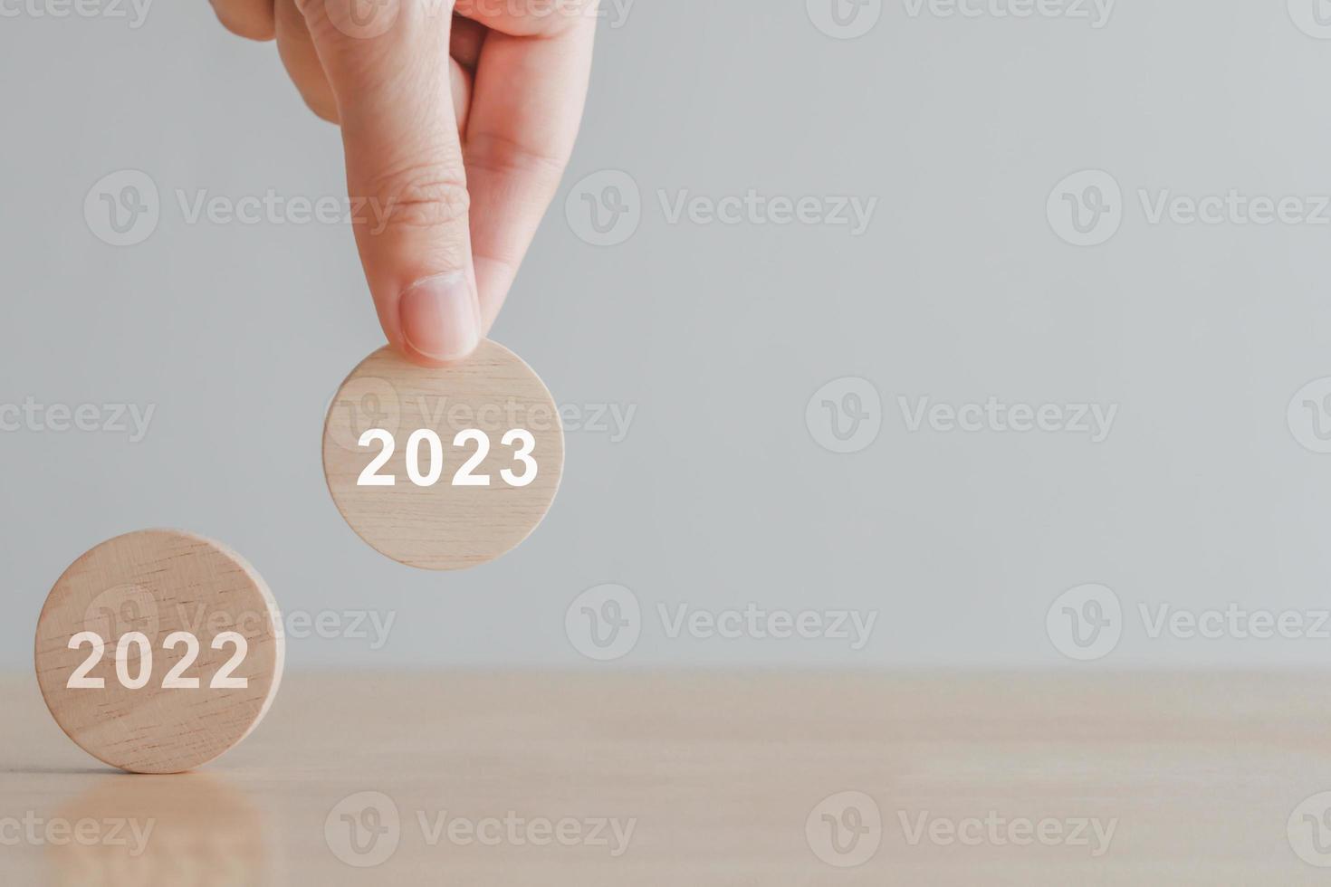 2023 new year challenge goal and target, Achievement, Business success. Hand holding 2023 from 2022 on floor. Set strategy and plan for future. Background for Merry christmas and Happy new year 2023. photo