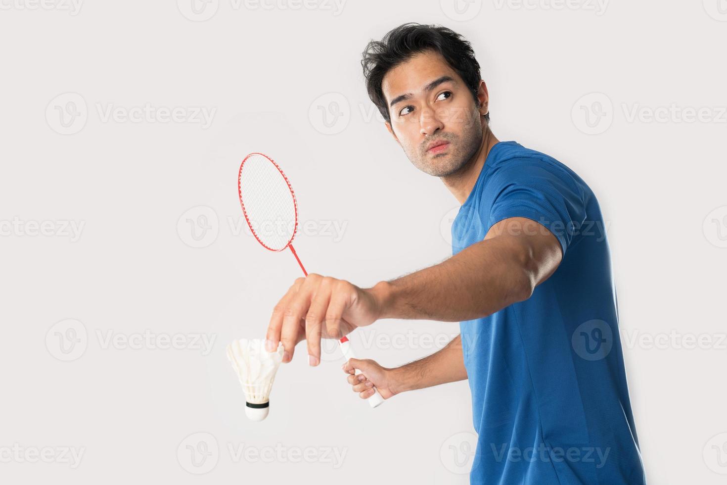 A badminton player in sportswear stands holding a racket and shuttlecock. photo