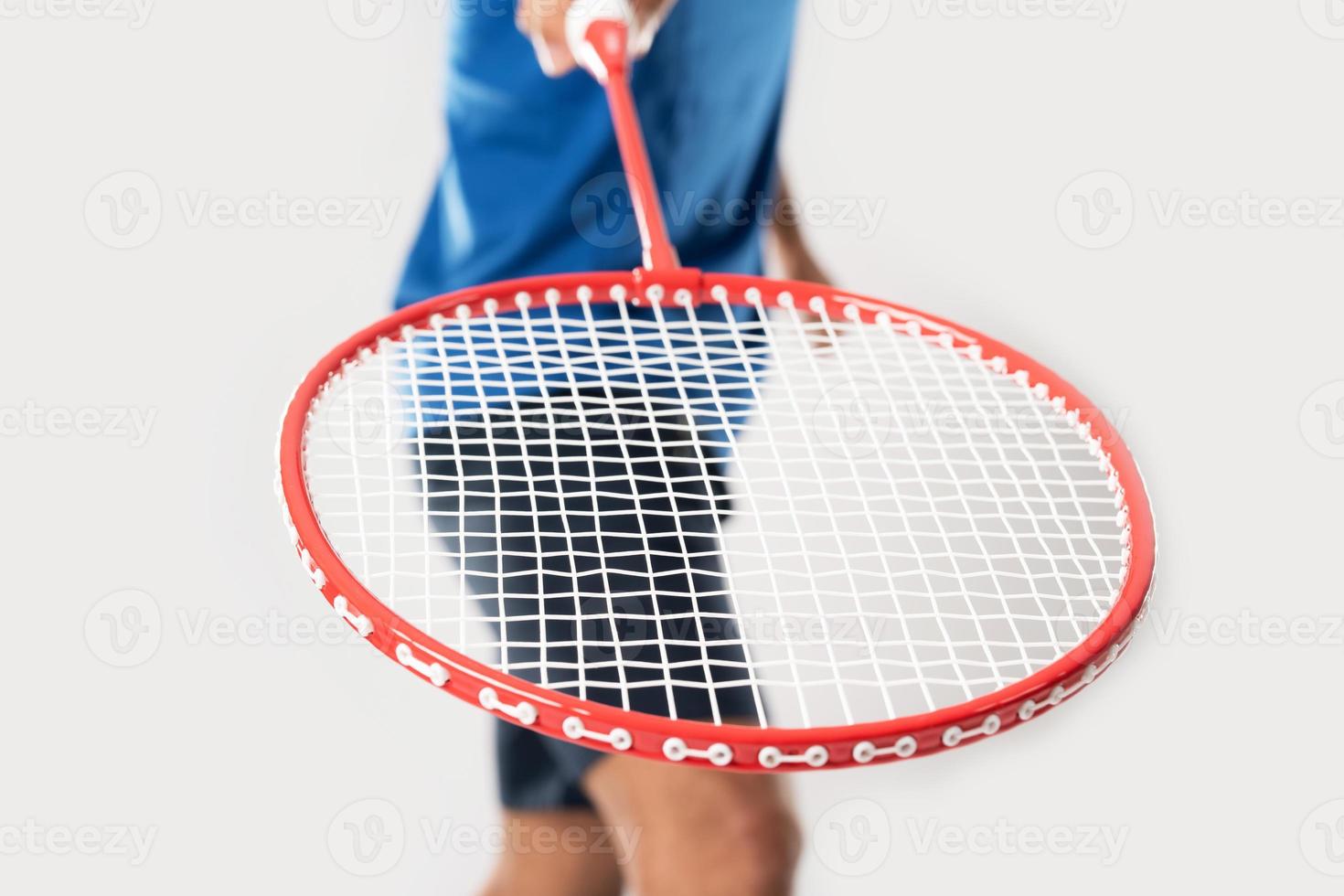 un jugador de bádminton con ropa deportiva sostiene una raqueta y un volante foto