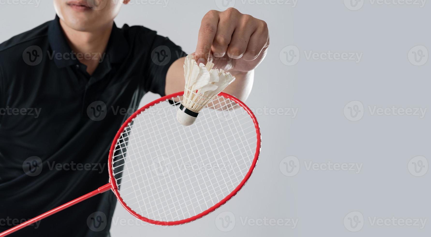 A badminton player in sportswear stands holding a racket and shuttlecock photo