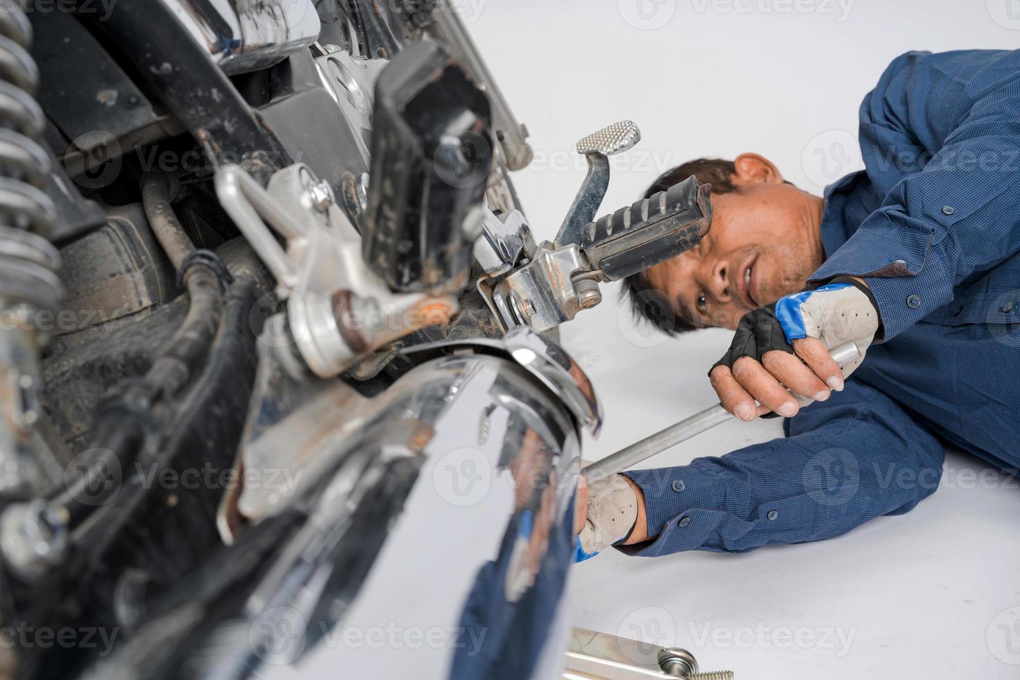 People are repairing a motorcycle Use a wrench and a screwdriver to work photo