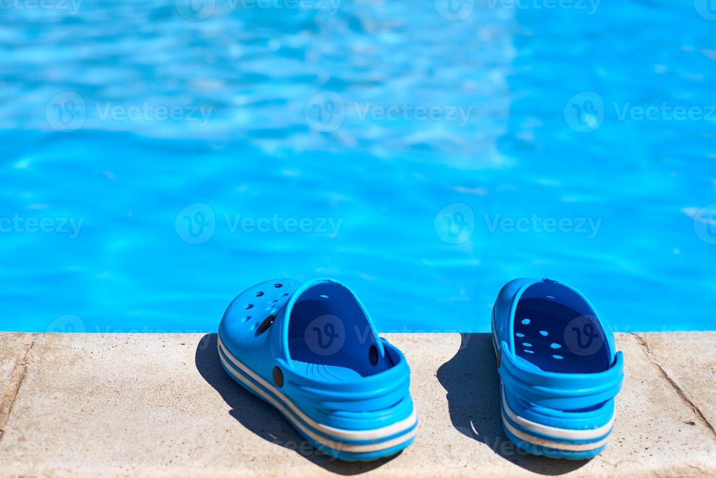 Blue flip flops near the swimming pool, close up photo