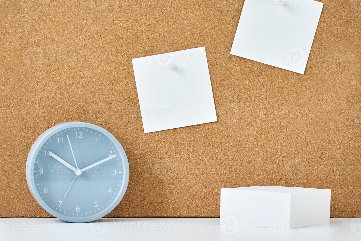 Sticky notes on a cork board and alarm clock in workplace office or home photo