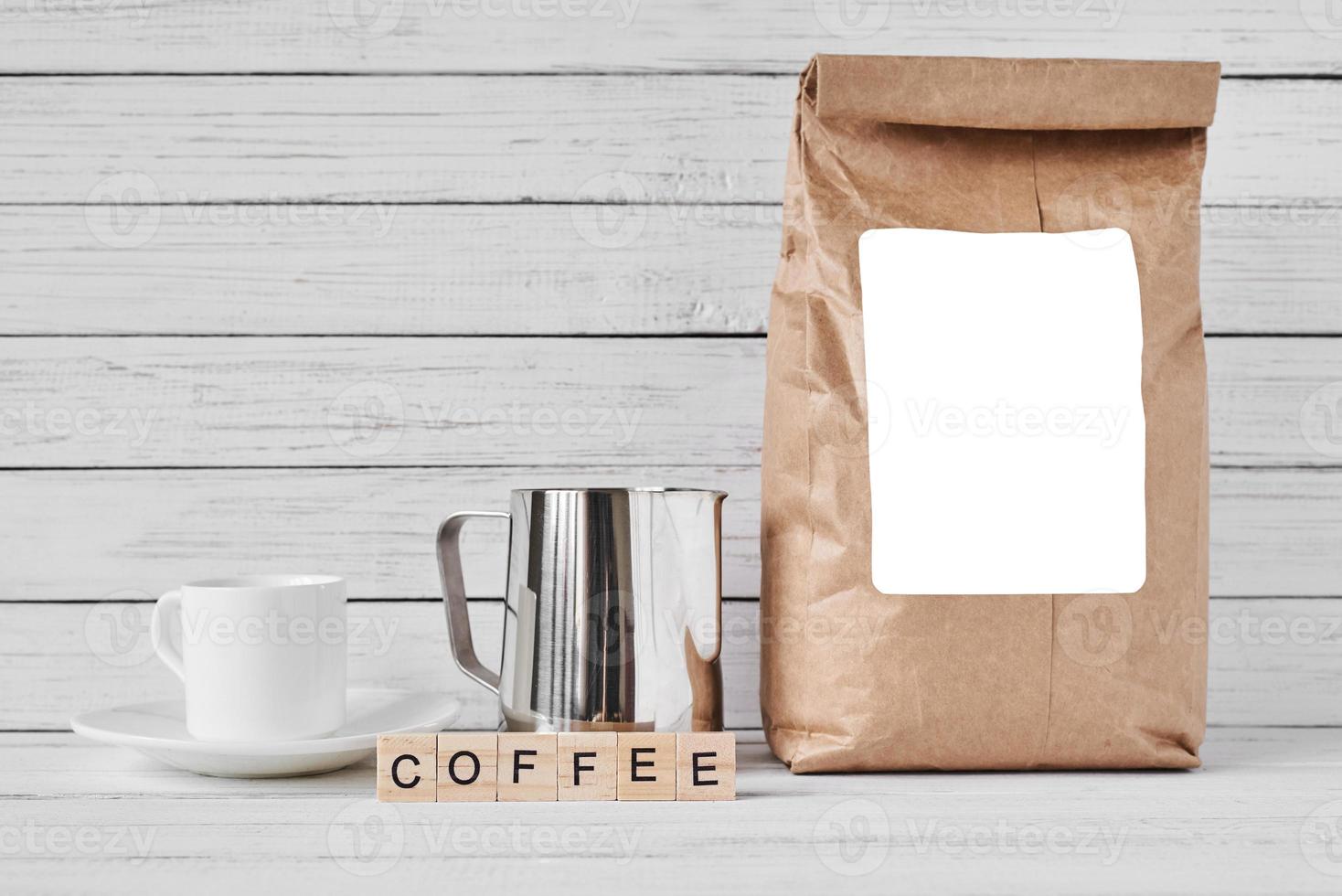 Coffee cup, craft paper bag and stainless pitcher photo