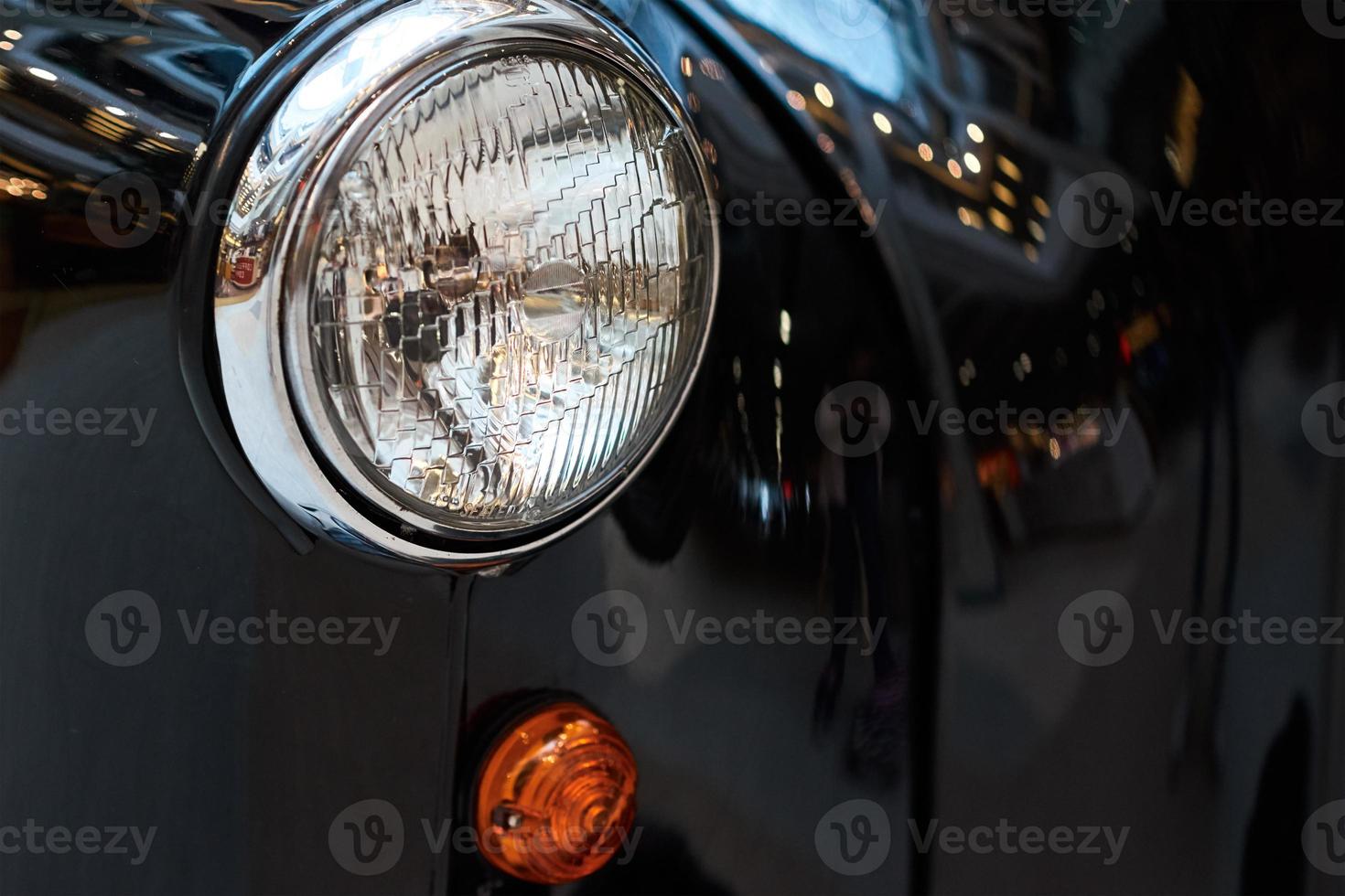 Close up headlight of a black vintage car photo