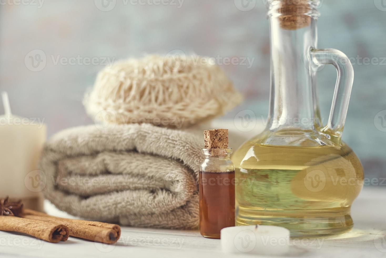 Towels, candle and massage oil on white table photo