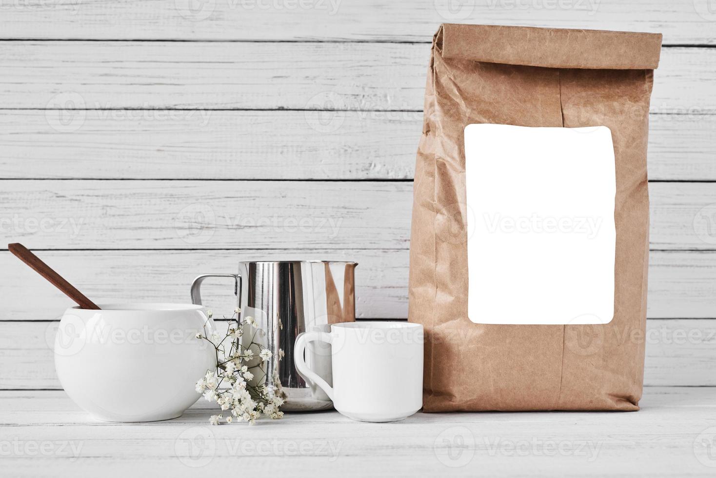 Coffee cup, craft paper bag and stainless pitcher photo