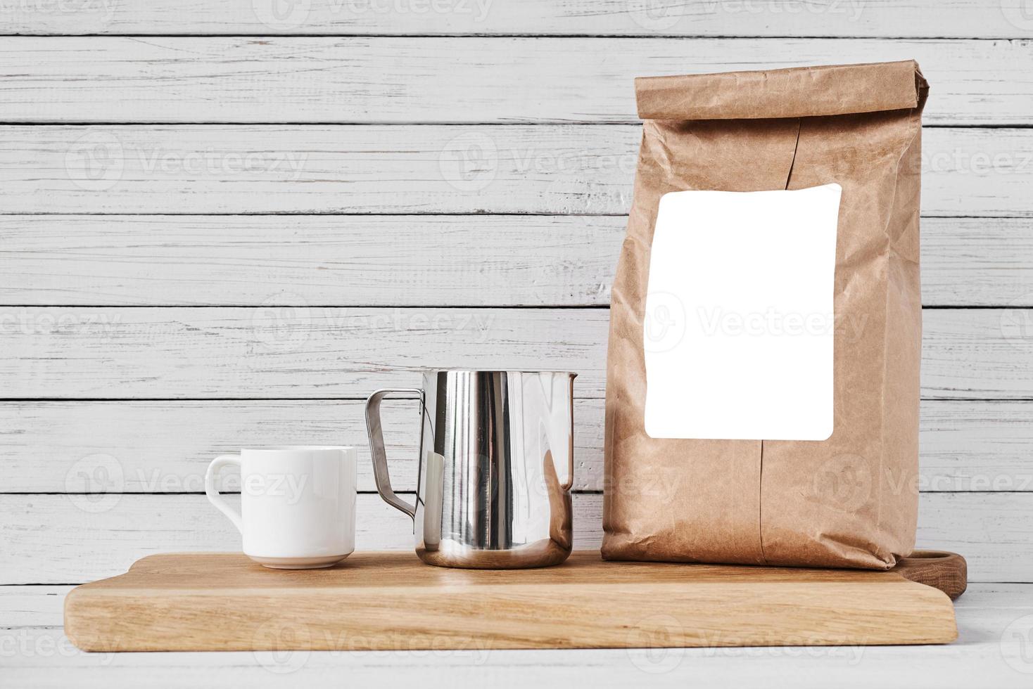 Coffee cup, craft paper bag and stainless pitcher photo