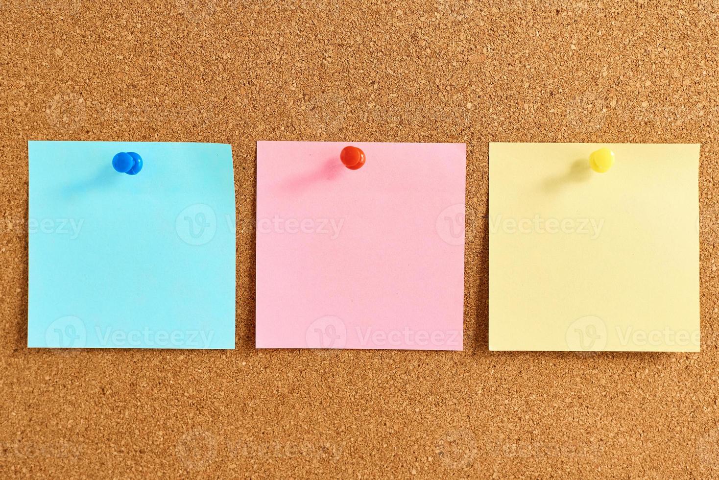 tablero de corcho con notas en blanco coloreadas fijadas foto