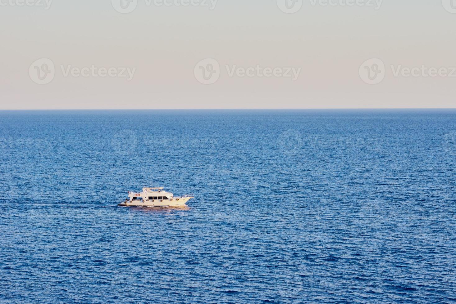 Trolling boat in a blue water of ocean photo