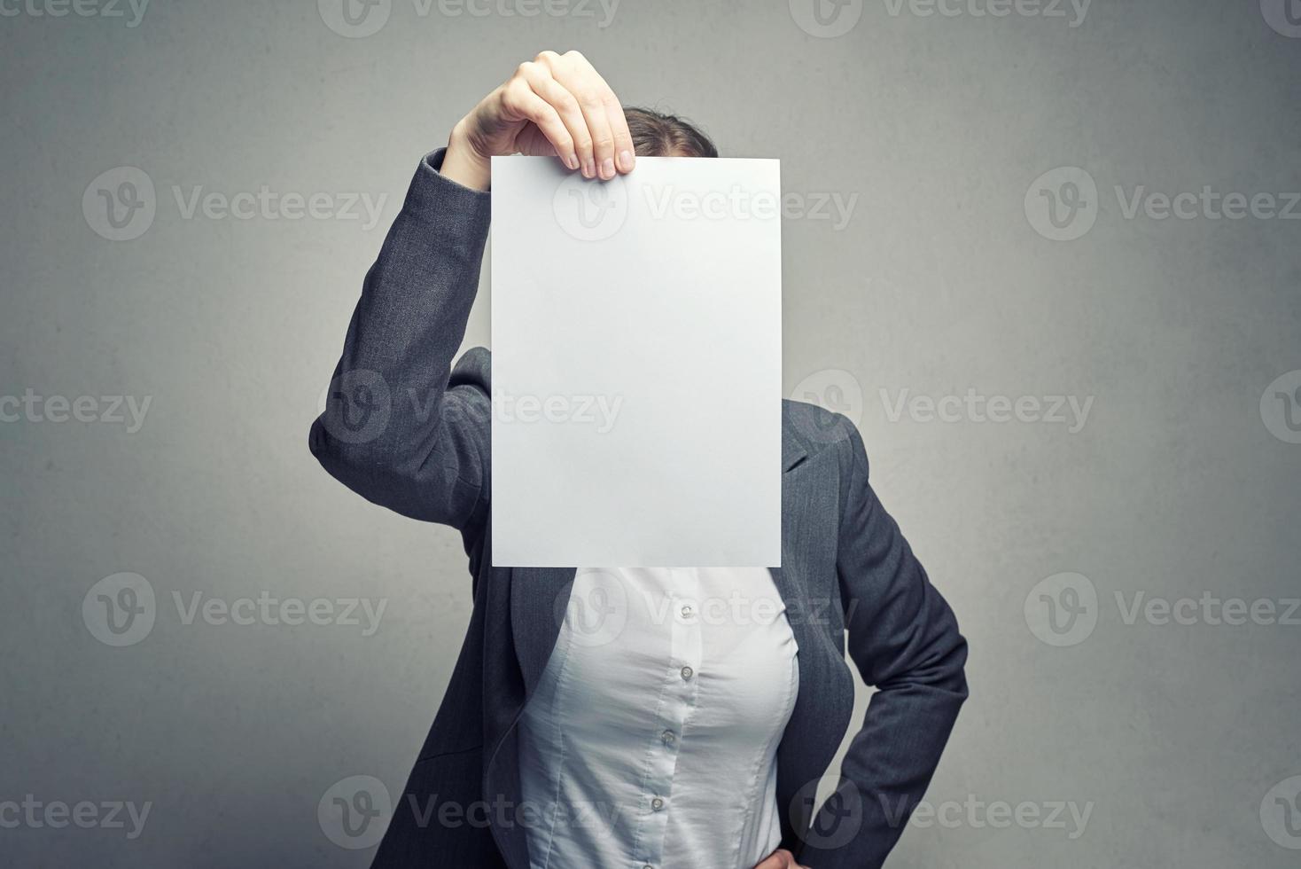 mujer anónima que cubre la cara con una hoja de papel foto